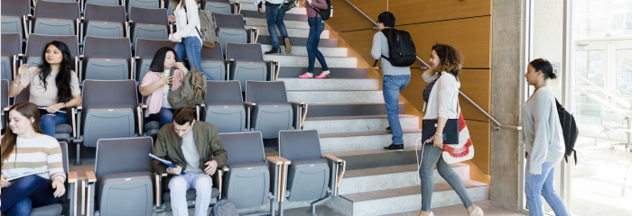 Students entering college lecture hall and walking up steps to seats.