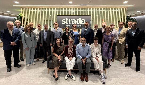 Group standing together at the Strada Foundation offices, in front of "strada" sign.